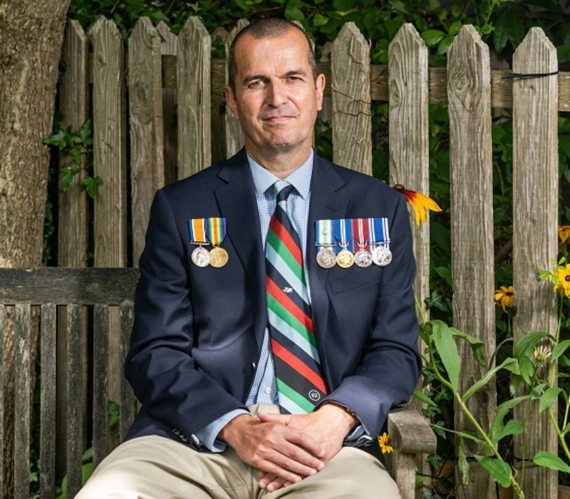 Charlie sat on bench wearing medals_square Charlie on bench wearing medals