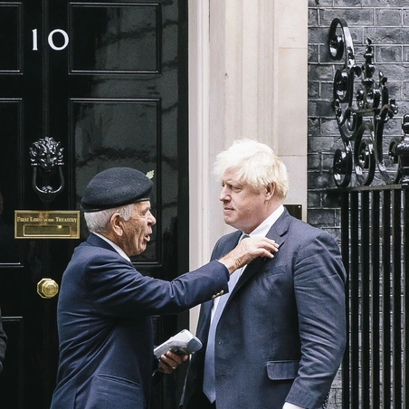 Collector pinning a poppy on Prime Minister Boris Johnson