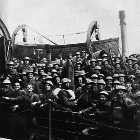 Dunkirk A black and white photo of British soldiers being evacuated from Dunkirk. They are tightly packed onto a ship and many are smiling and waving to the camera.