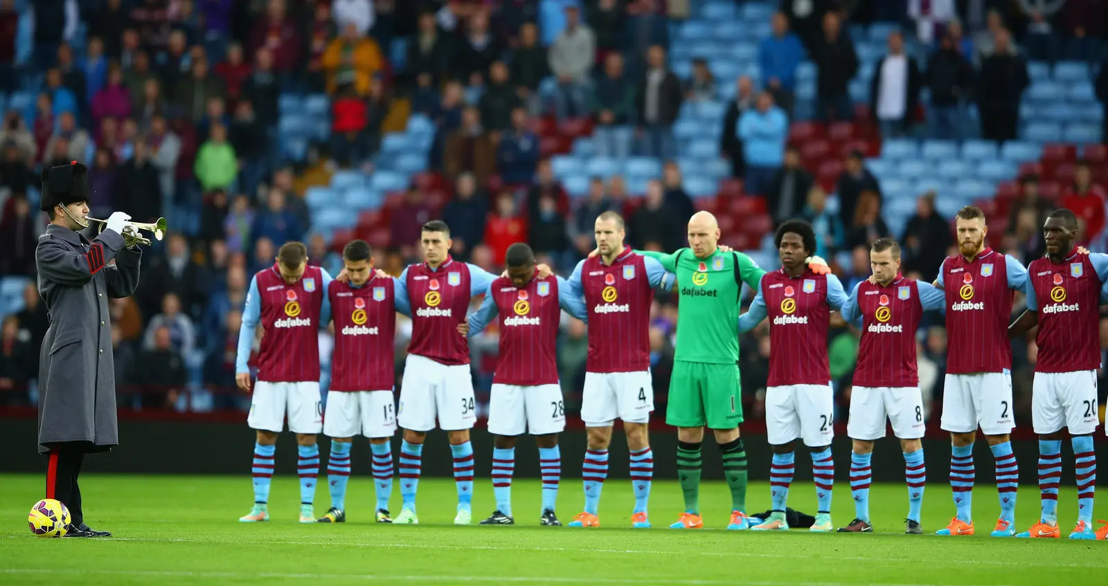  The 'Last Post' is played as players mark Remembrance Day at Aston Villa Park