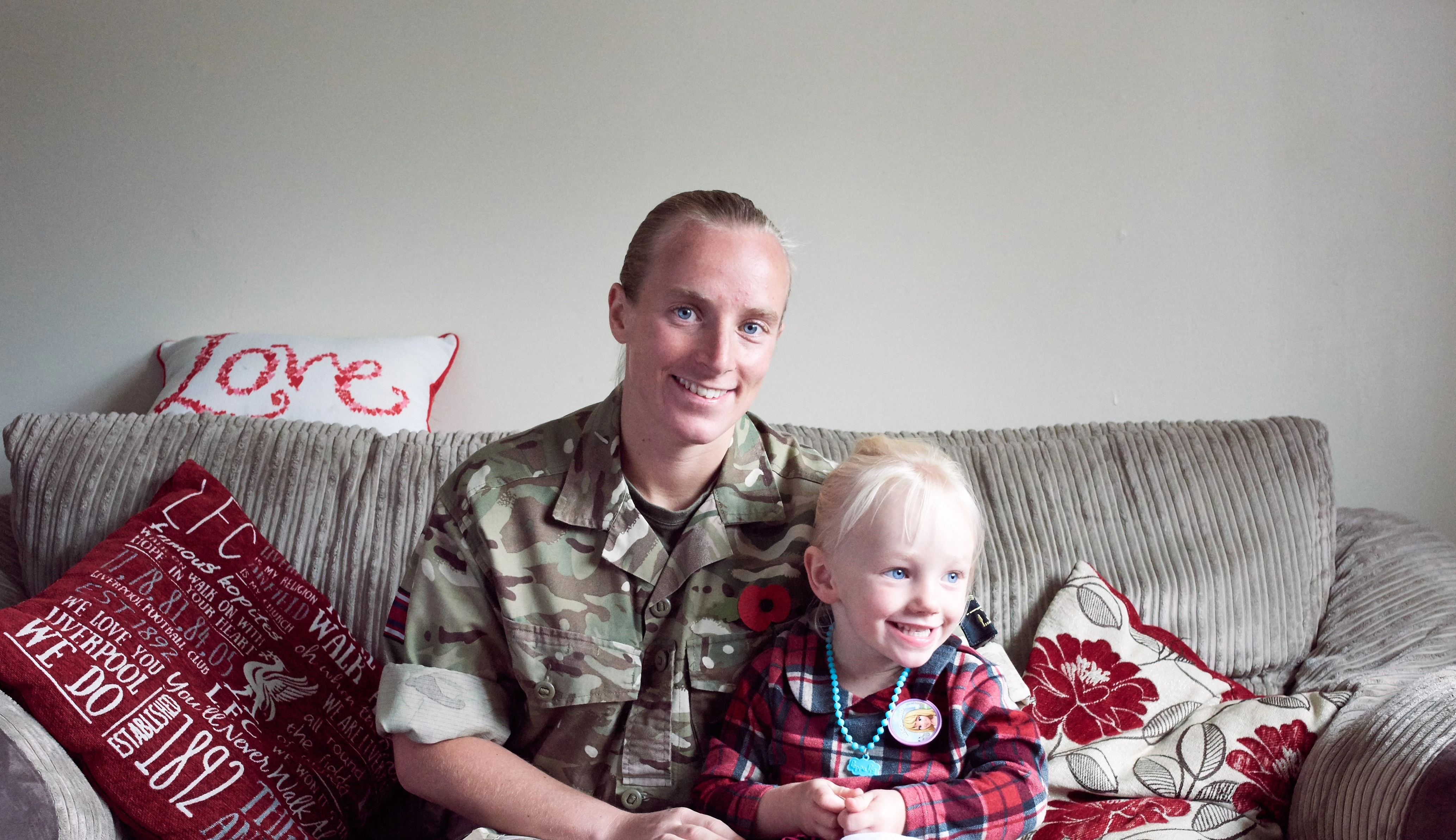 Army Healthcare Assistant in battledress at home with young daughter