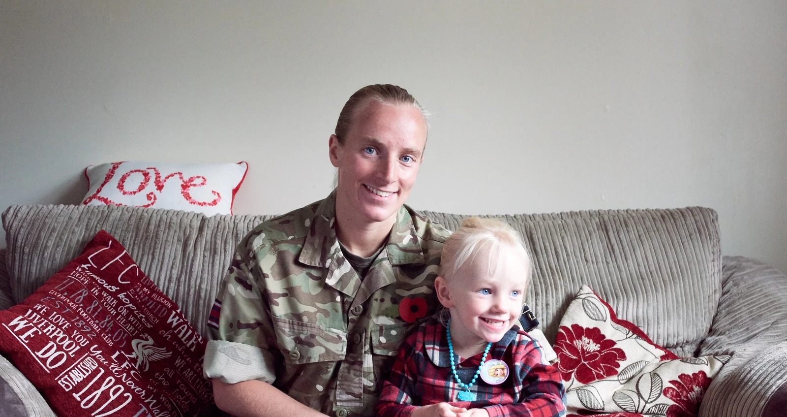 Army Healthcare Assistant in battledress at home with young daughter