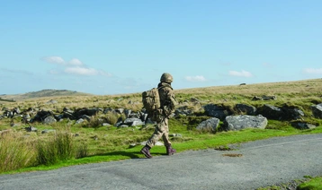 Soldier walking alone along roadside