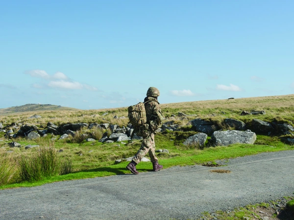 Soldier walking alone along roadside