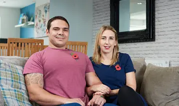 A couple who have received support from the Royal British Legion sitting on a sofa