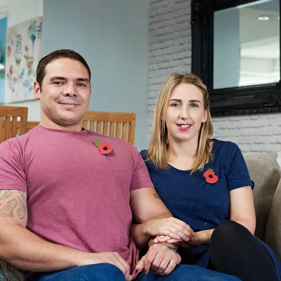 A couple who have received support from the Royal British Legion sitting on a sofa