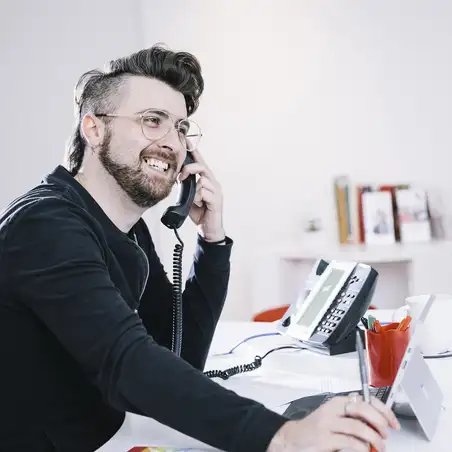 LGBTQ+ Telephone Card Image Man on telephone at desk
