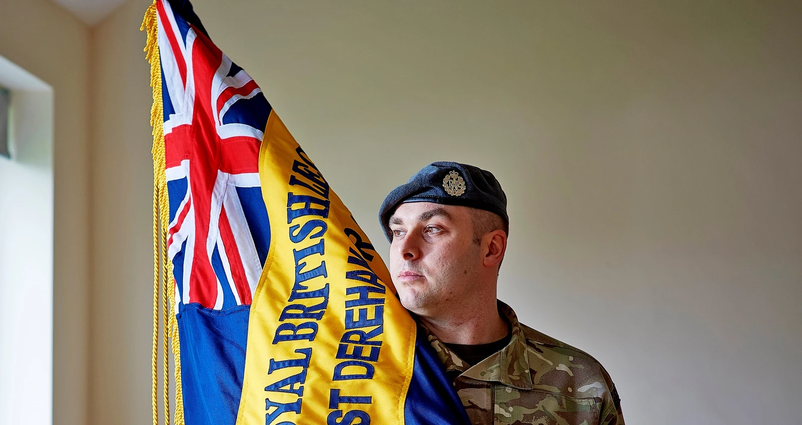 Tom Foy carries branch Standard Tom Foy in battledress holds his branch Standard