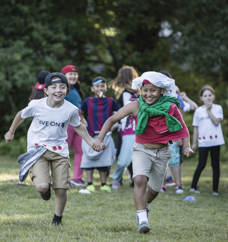 Two boys holding hands and running at a Royal British Legion Youth Membership event