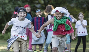 Two boys holding hands and running at a Royal British Legion Youth Membership event
