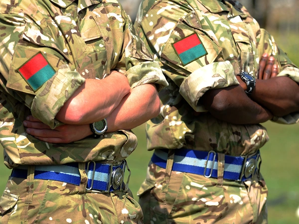 Soldiers from the Commonwealth Two soldiers in camouflage uniform with crossed arms