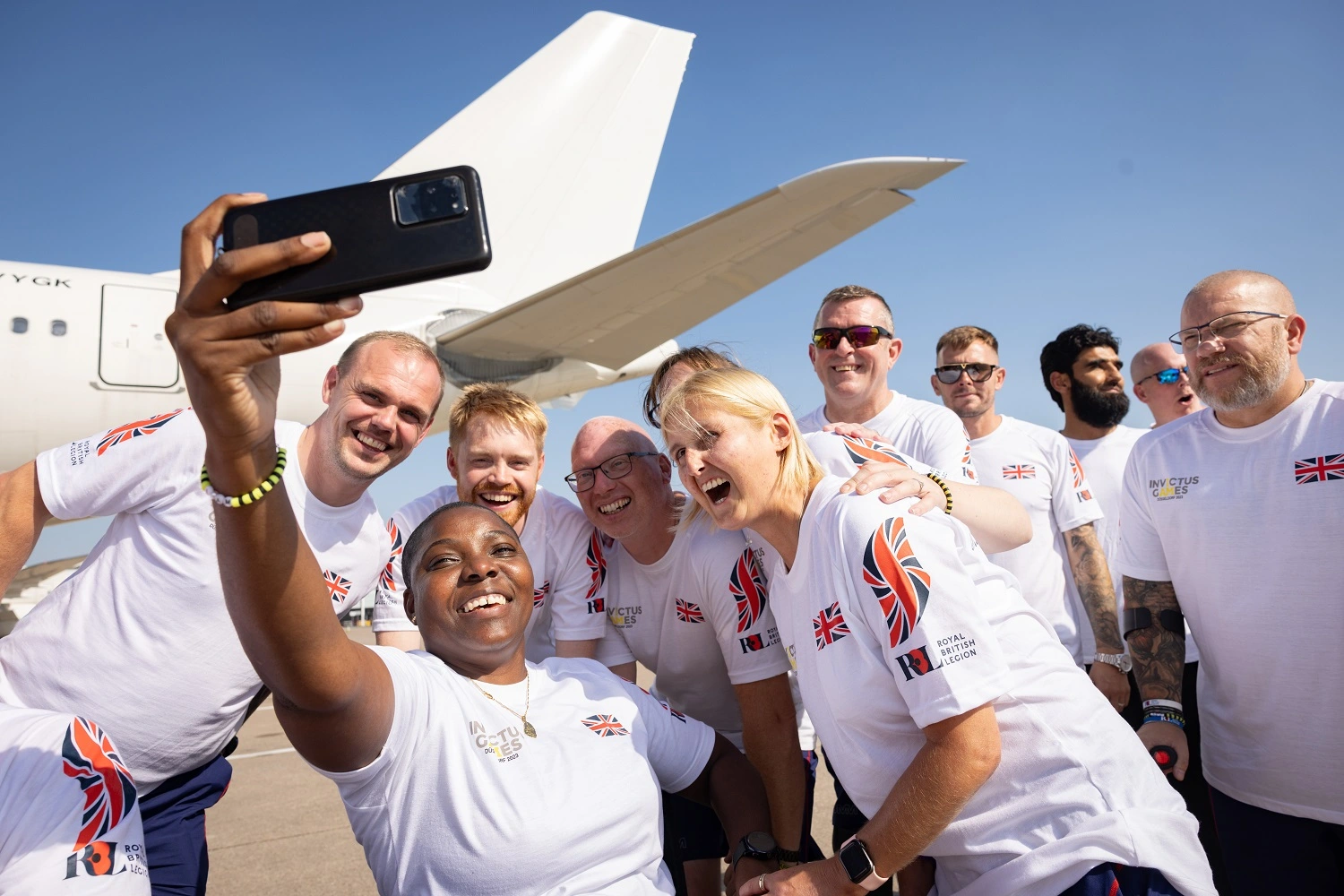 Team UK competitors taking a selfie in front of a plane before travelling to Germany