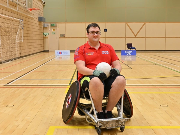 Matthew Trigg sat in a wheelchair holding a ball