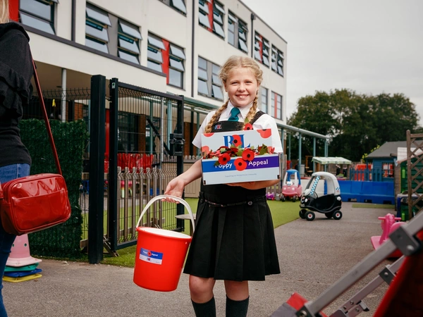 Maisie Mead with collection bucket outside her school Maisie Mead with collection bucket outside her school