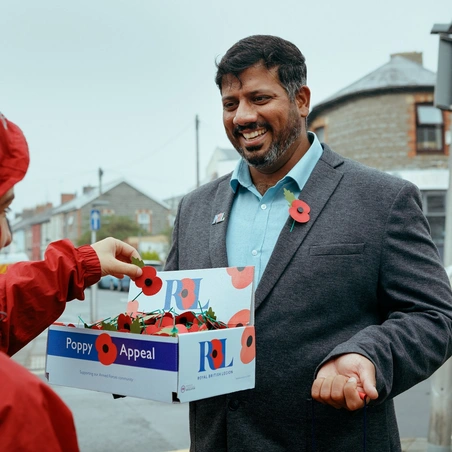 Mirza Shahzad giving a poppy to member of the public Mirza Shahzad giving a poppy to member of the public