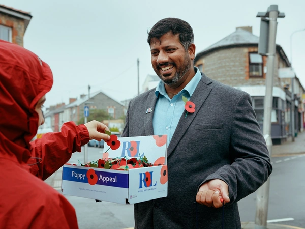 Mirza Shahzad giving a poppy to member of the public Mirza Shahzad giving a poppy to member of the public