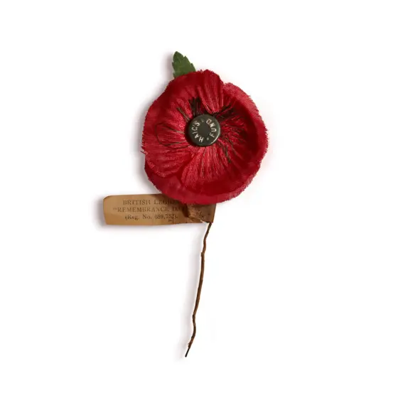 A 1930s poppy made from two layers of different fabric. The design features a green fabric leaf, faux stamens and a metal centre.