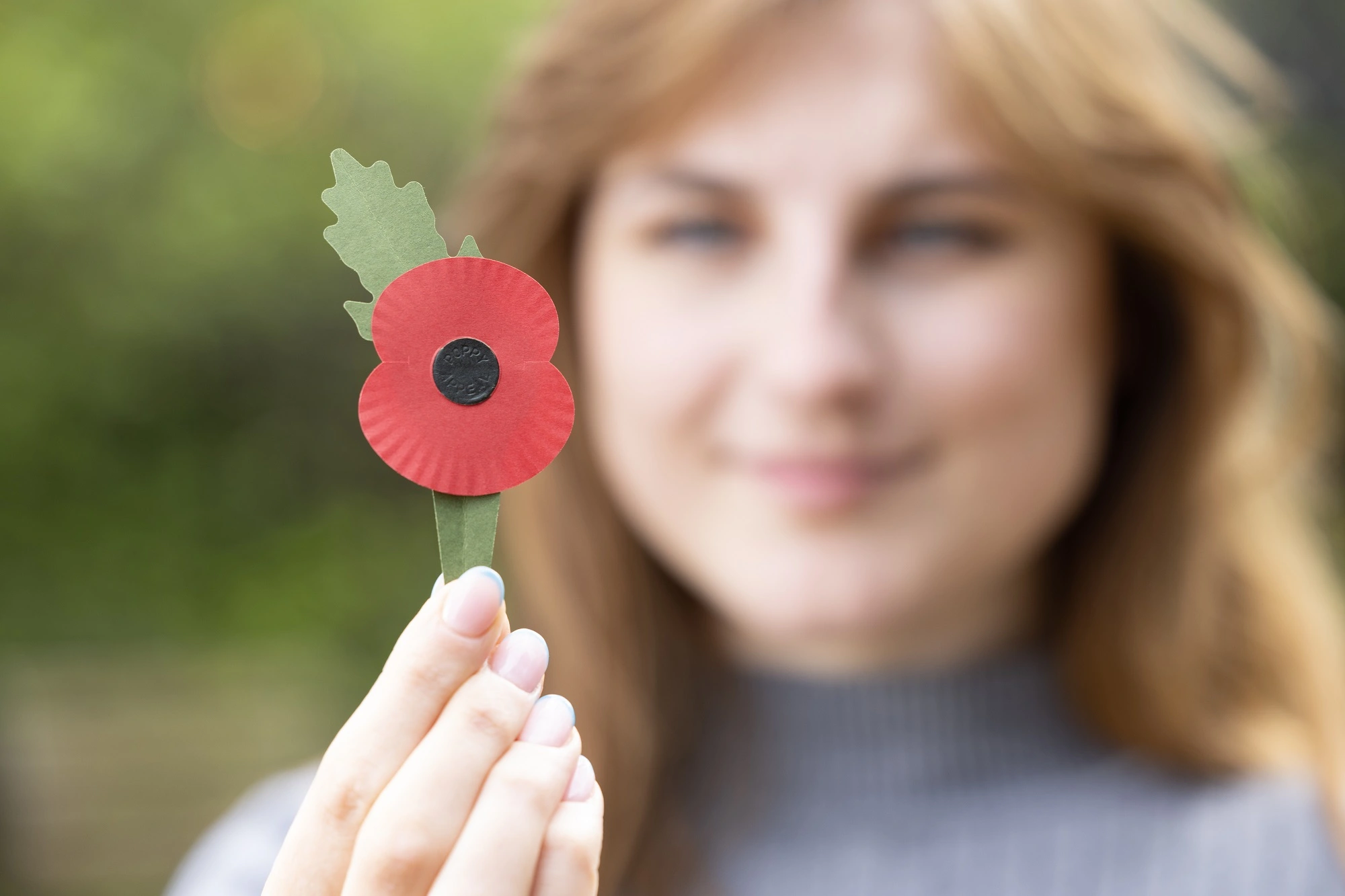 A new plastic-free poppy being held in one hand