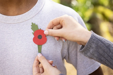 RBL_POPPY-43 A new plastic-free poppy being pinned onto the left side of a persons chest
