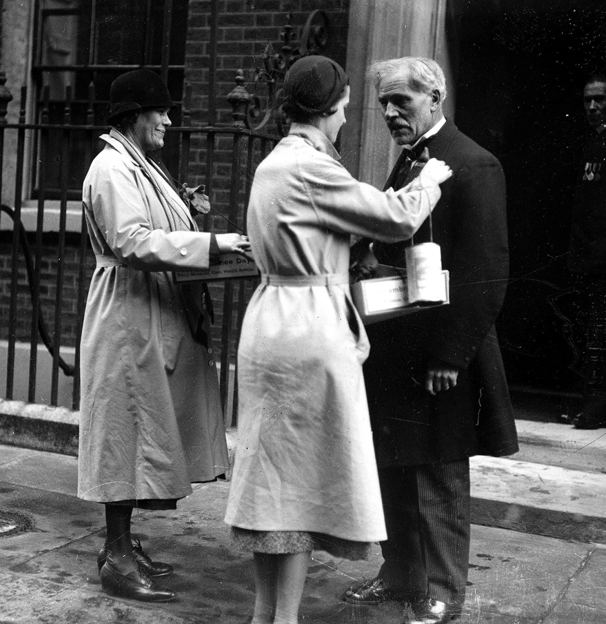 Ramsey McDonald receiving poppy on Downing St in 1937