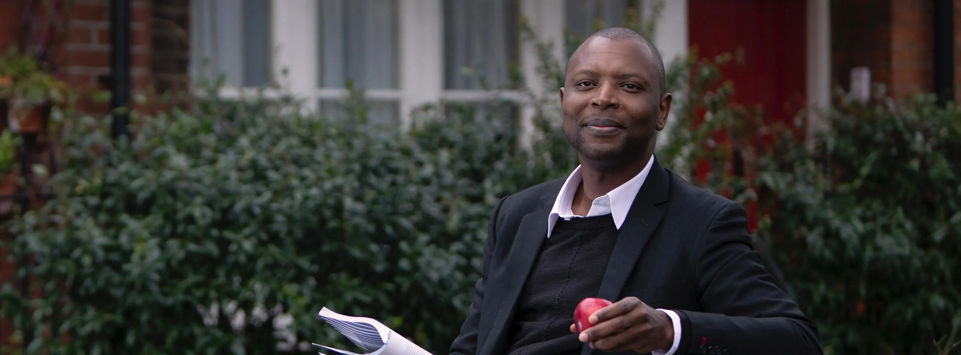 Man sitting on bench with apple