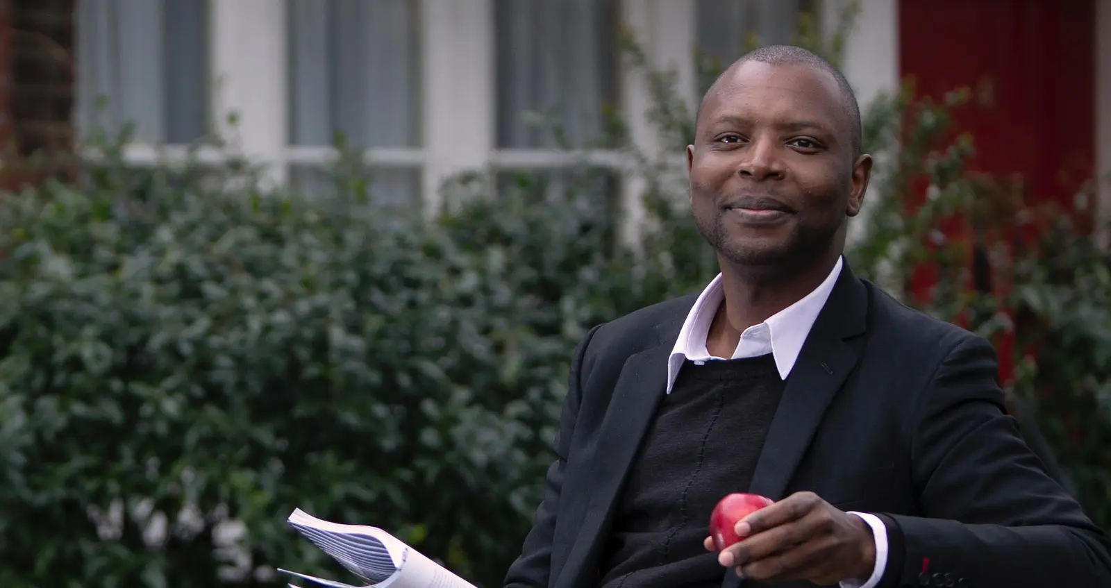 Employee Story_Henry Man sitting on bench with apple