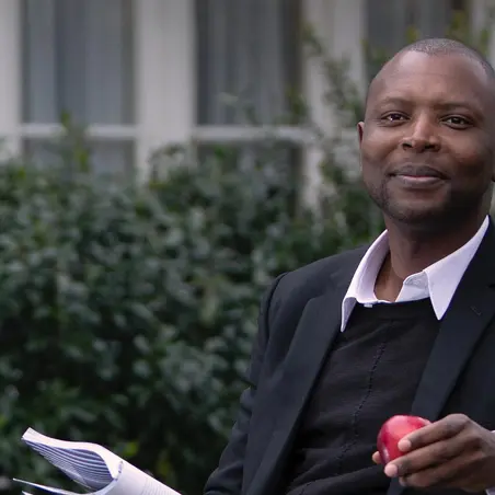 Employee Story_Henry Man sitting on bench with apple