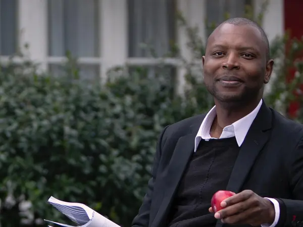 Employee Story_Henry Man sitting on bench with apple