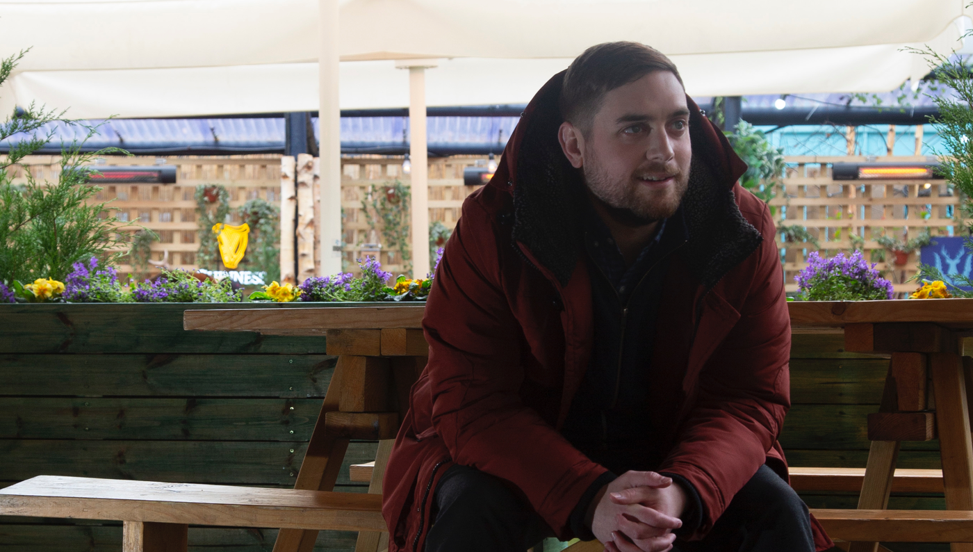 Man on bench wearing coat