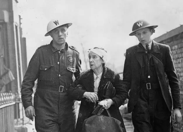 An injured woman in Liverpool is helped to a reception centre from a First Aid Post