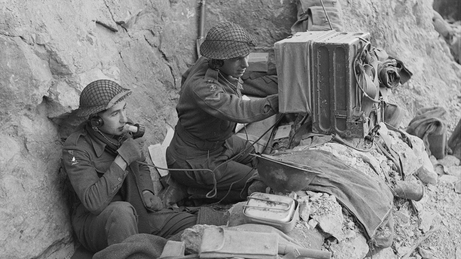 Troops sing a radio in a dugout on Monastery Hill.