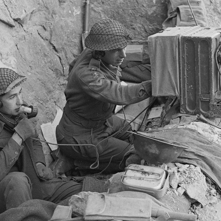 Troops sing a radio in a dugout on Monastery Hill.