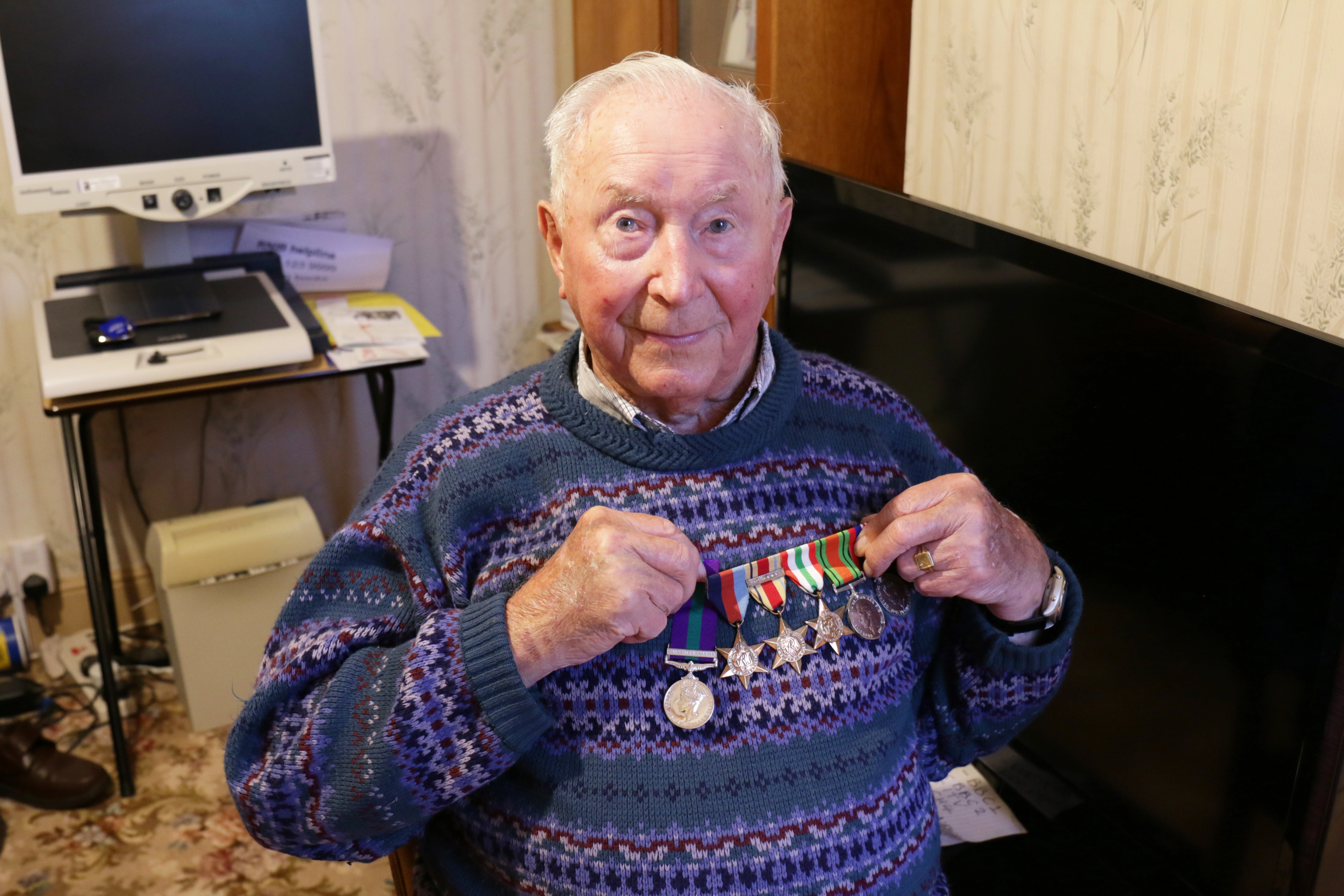 Walter Nixon holding up his medals