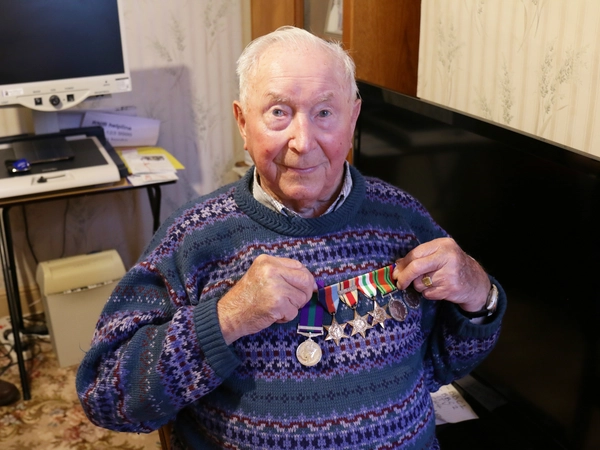 Walter Nixon holding up his medals