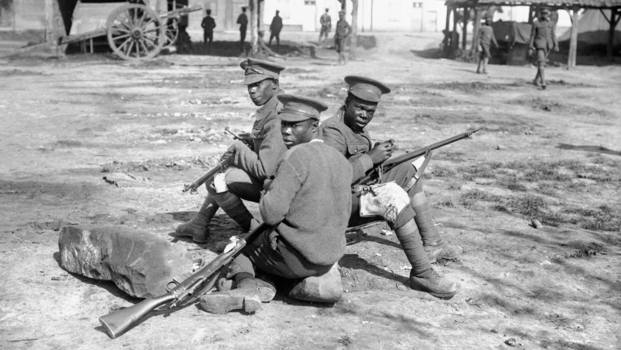 Three West Indian soldiers sitting with guns