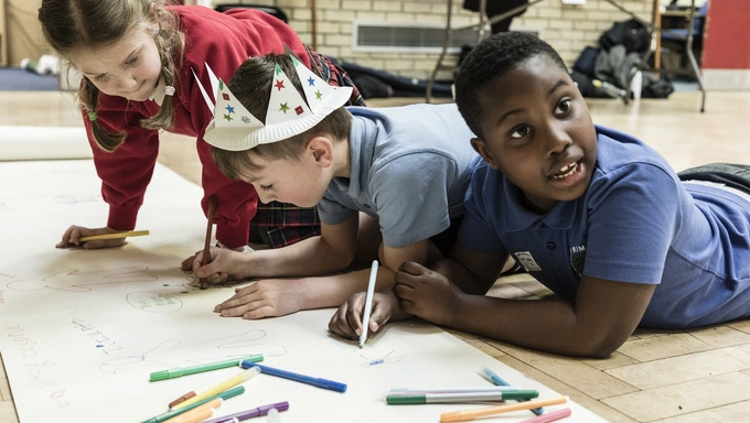 Children at a Military Kids Club Heroes drawing together on the floor. 