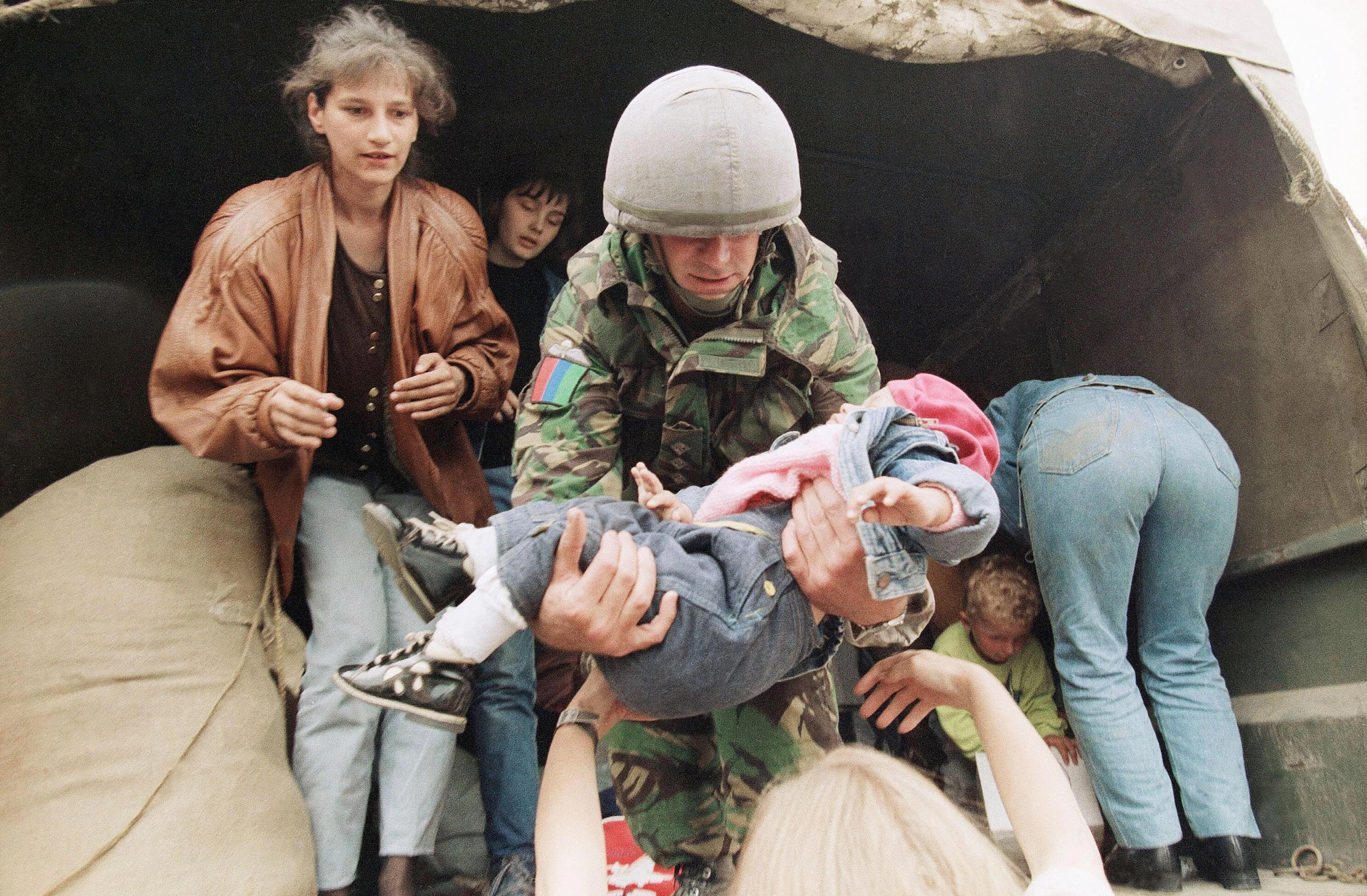 Soldier from the Prince of Wales's Own Yorkshire Regiment hands down a small refugee child May 1993 in Travnik