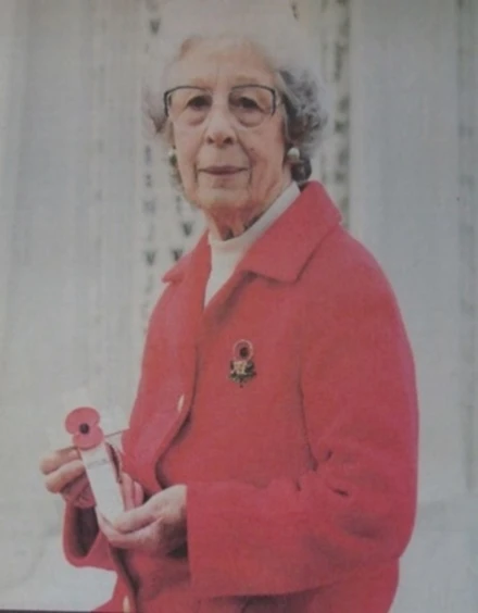 Photograph of Joan Bunn holding a Remembrance Cross