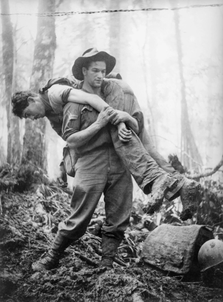 Wounded soldier being carried through jungle