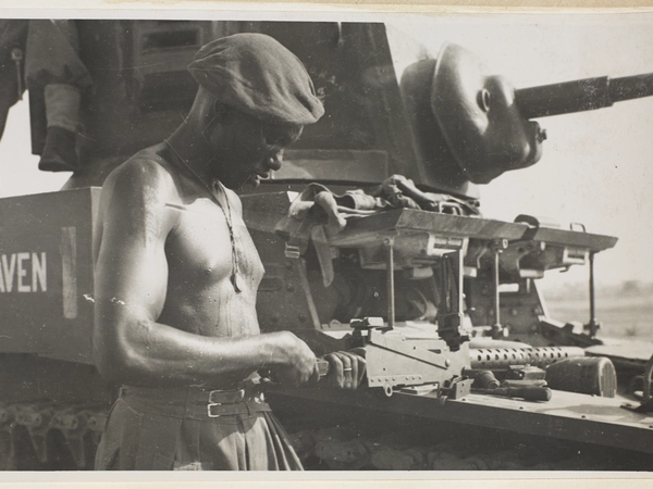 A soldier from the East African Reconnaissance Regiment, checking a machine-gun, Burma