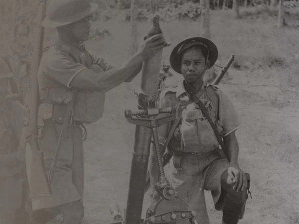 VJ DAY-LANDINGPAGE-THEMEHERO-2-ASSET-006 A group of Malaysian soldiers, under the command of the British, prepare to fire a mortar during a battle on the Malay Peninsula