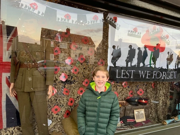 Harry in front of a window display of his handmade poppies