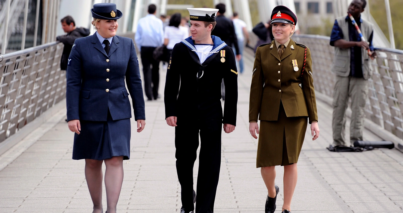 Armed Forces Day Three uniformed personnel walking across a bridge