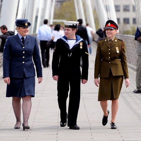 Armed Forces Day Three uniformed personnel walking across a bridge