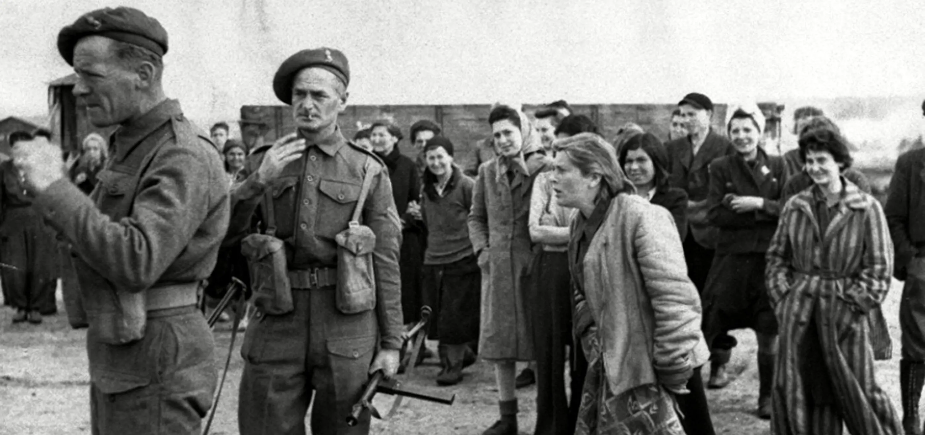 A young woman internee at the Bergen Belsen concentration camp shouting at Allied troop as they supervise German POWs to clean up the cam