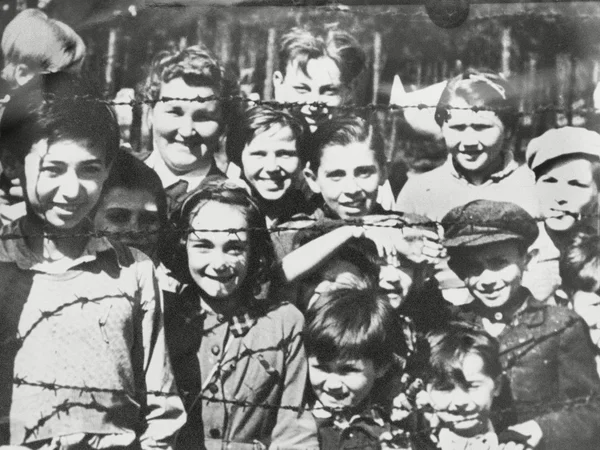 Children behind barbed wire at Bergen Belsen concentration camp