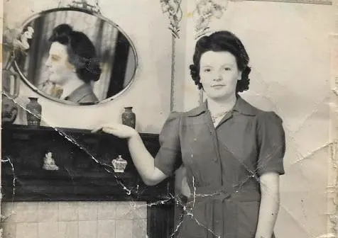 Betty in posing in front of a fireplace in the 1940s.