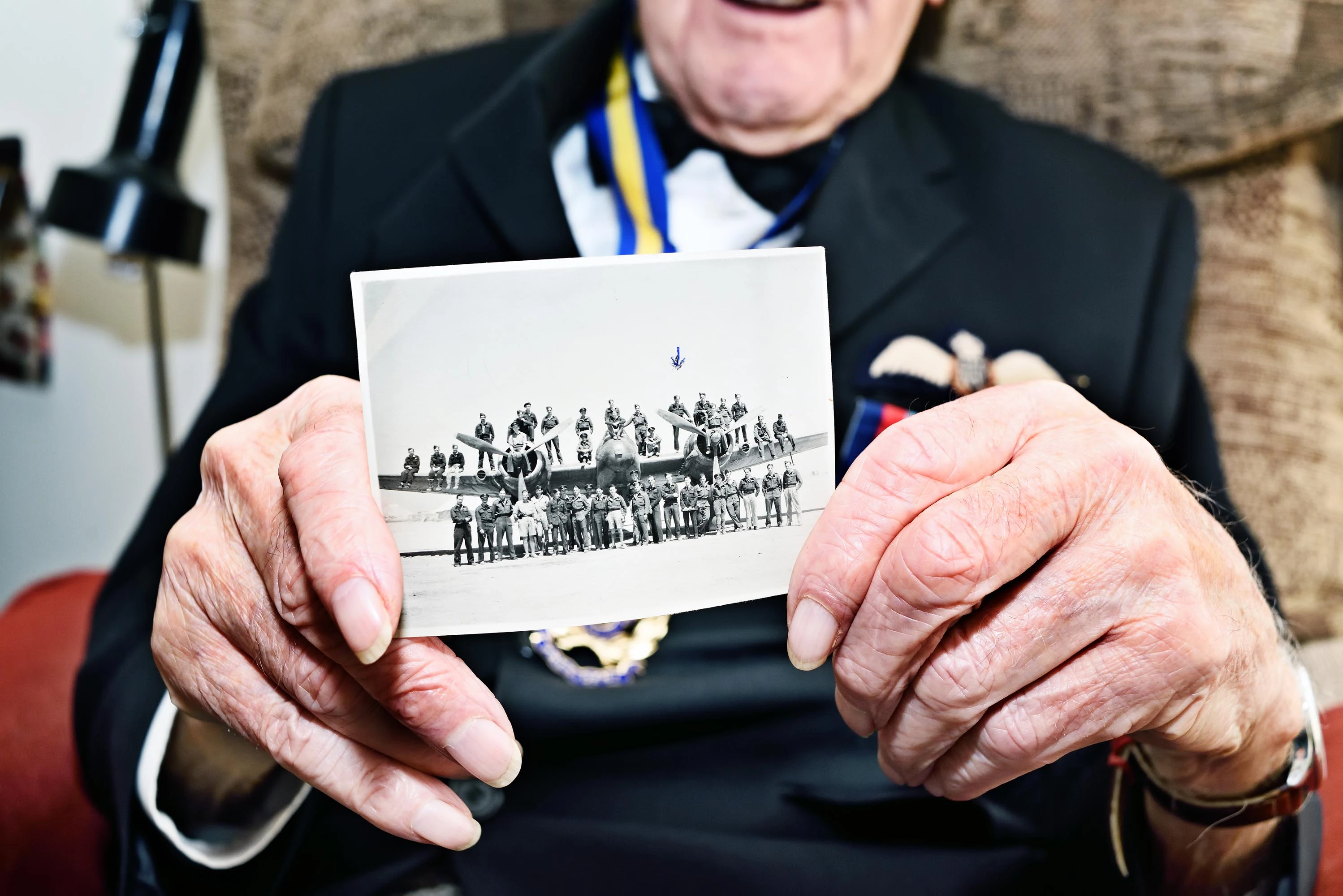 Bill Harrison holds photo of 603 Squadron crew from 1944