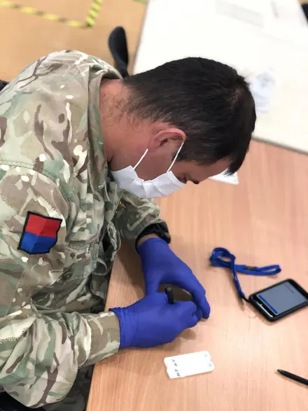 Member of 4th Regiment Royal Artillery labelling a swab at a Covid-19 test centre
