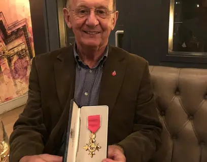David Cole showing his OBE medal